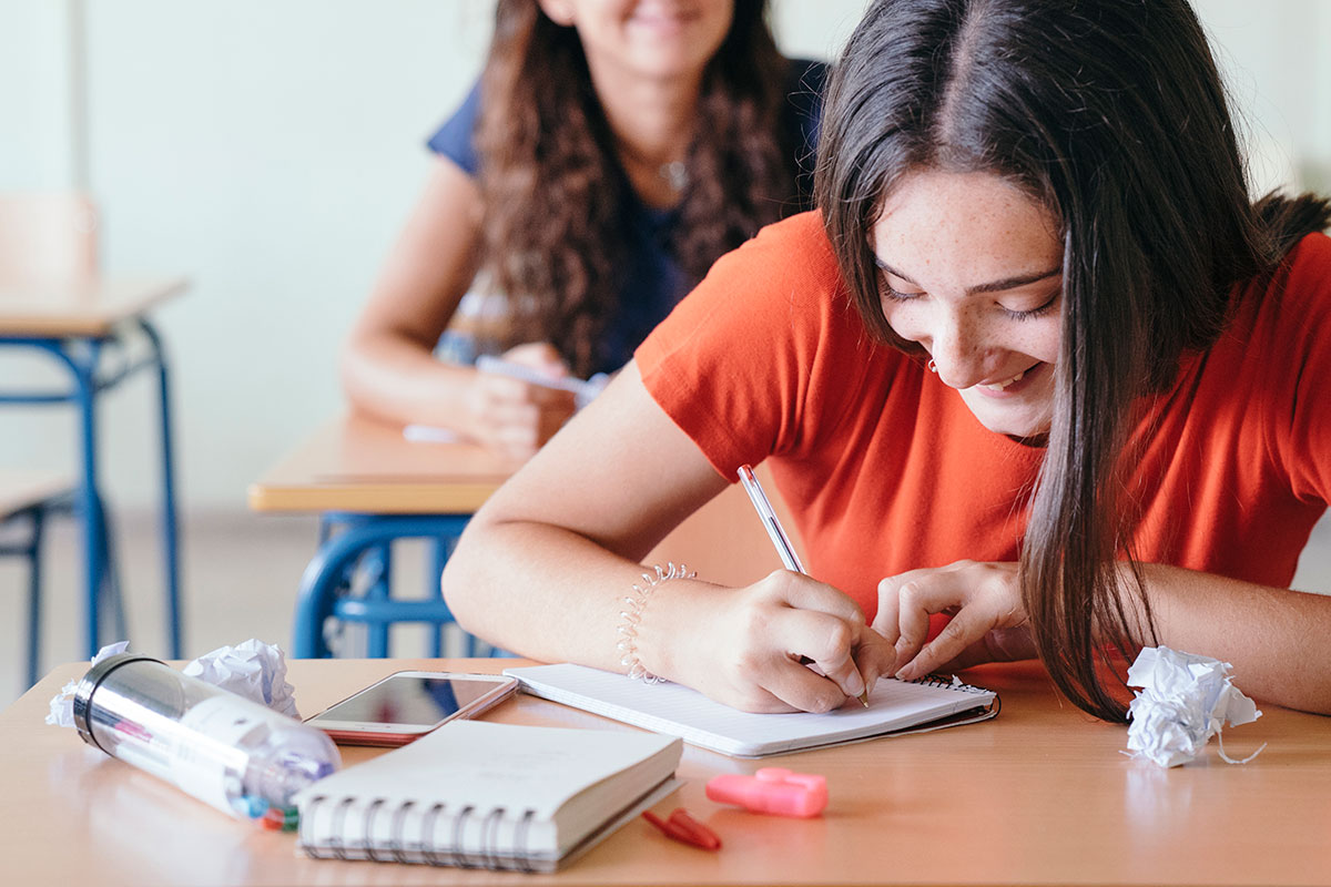 Estudiante concentrada en su pupitre en el Instituto Mercedes Lemus Zamora, comprometida con terminar su enseñanza básica o media.